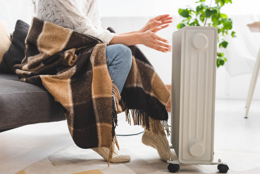 cropped view of girl with blanket warming up with heater in cold room - Best Portable Space Heaters of 2021