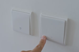 Hand switching on the light with the best smart home dimmer switch