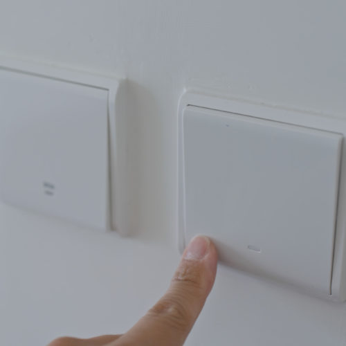 Hand switching on the light with the best smart home dimmer switch