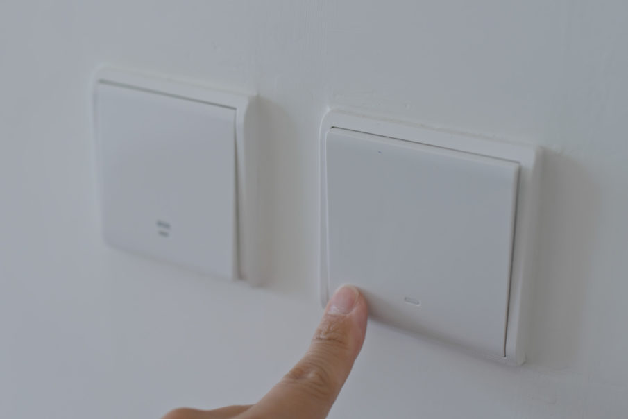 Hand switching on the light with the best smart home dimmer switch